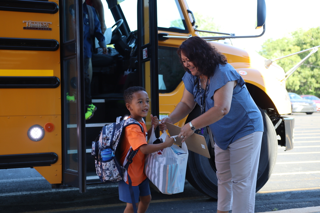 Mrs. Hayes helps student off the bus at SHES.